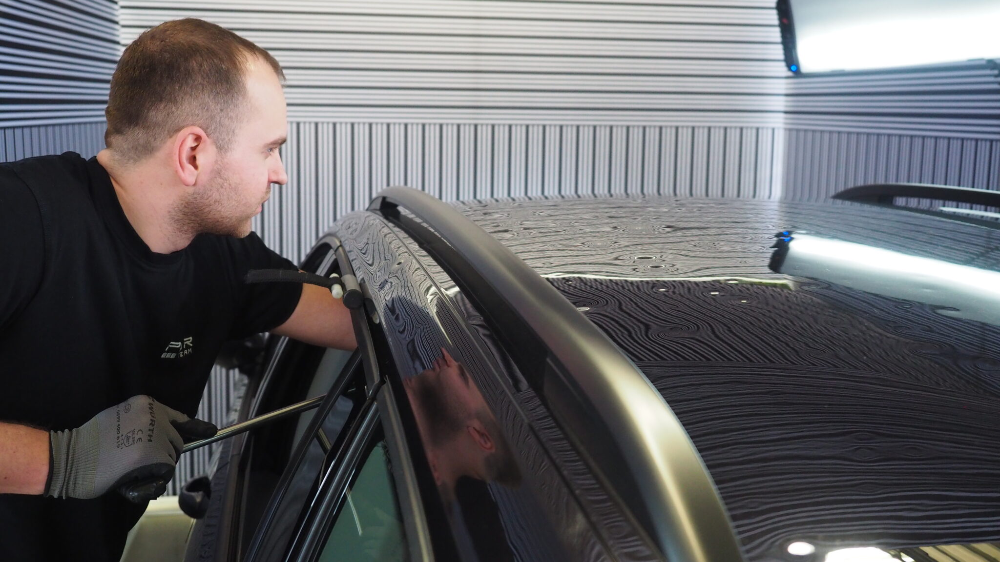 Paintless dent repair technician working on a vehicle panel